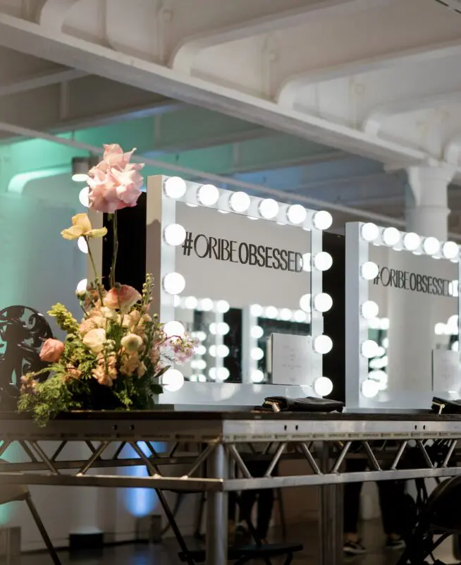 Lightbulb vanity mirrors and florals at an Oribe brand activation