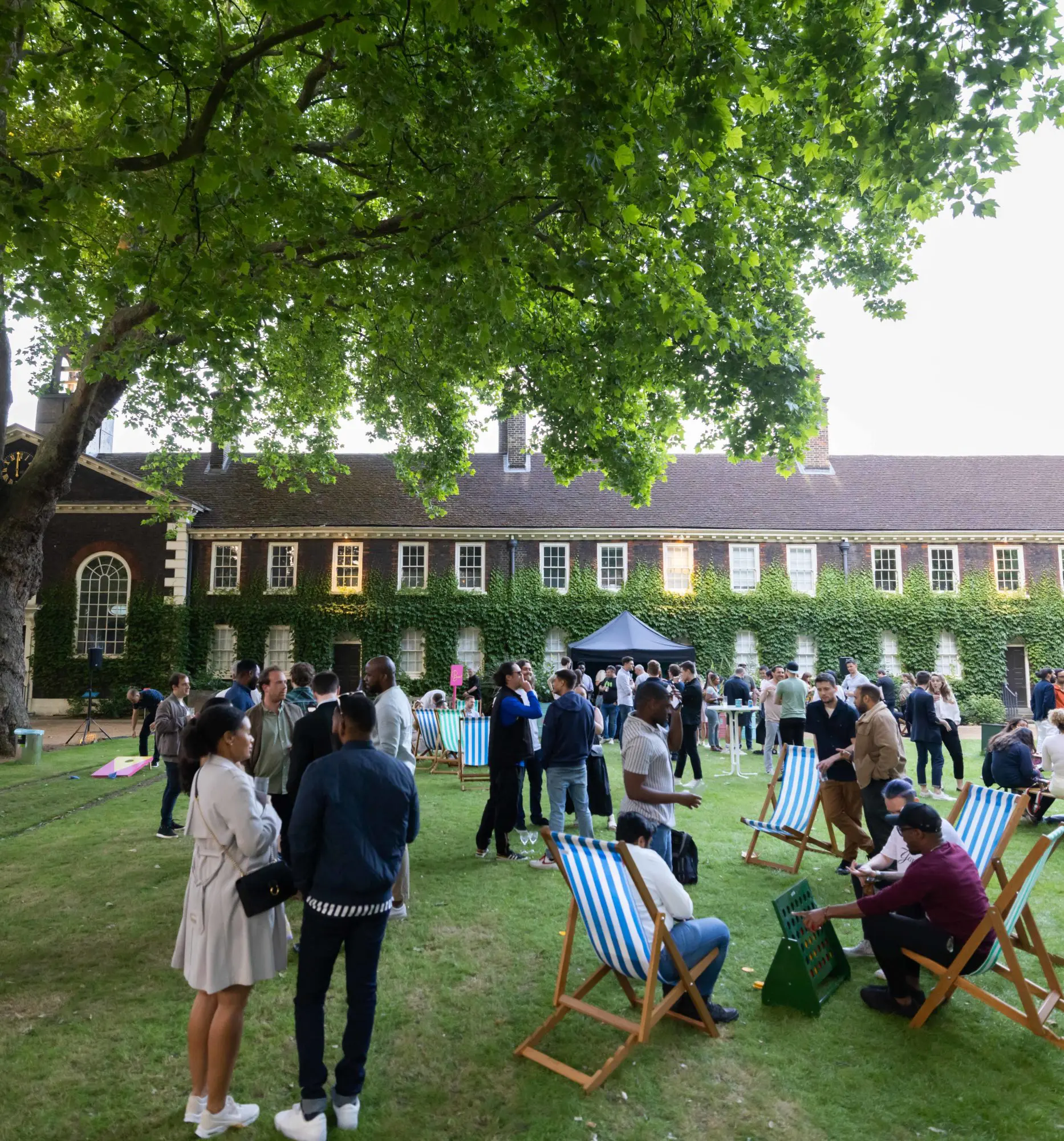 Guests relaxing in striped deckchairs on the lawn at Shoreditch Gardens