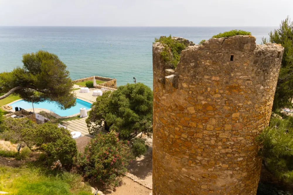 Coastal grounds with a swimming pool and historic stone tower