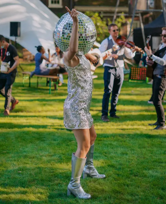 Guest dancing with a mirror ball on the lawn at Shoreditch Gardens