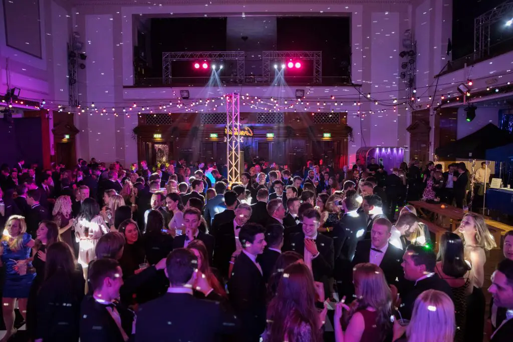 Guests at a Christmas party in a large decorated hall