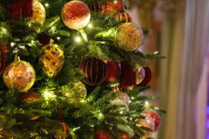 Gold and red baubles on a decorated Christmas tree