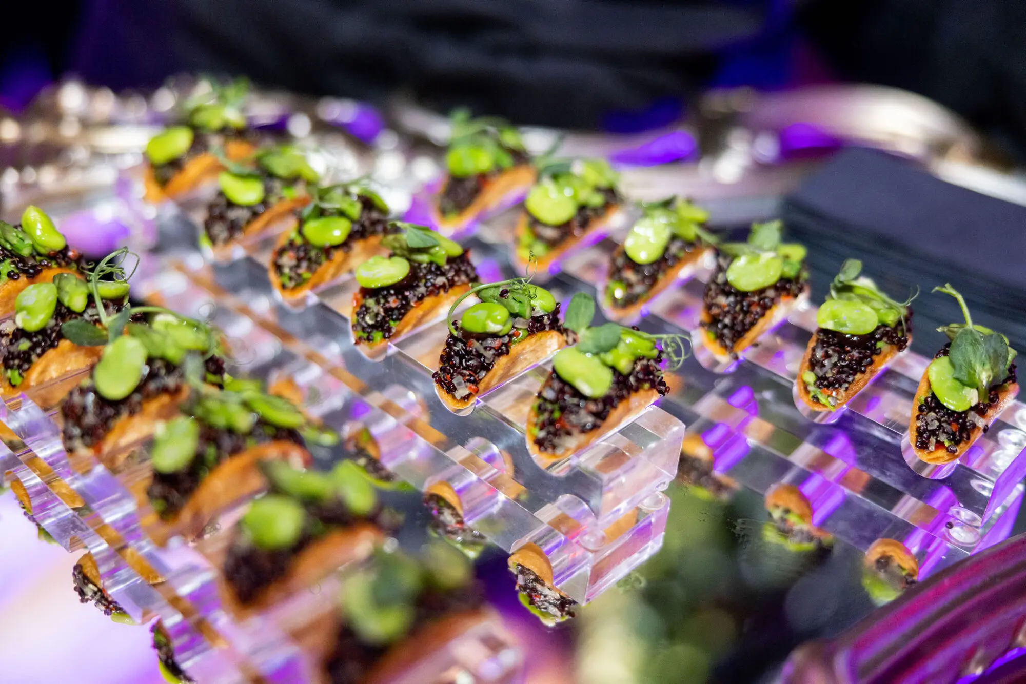 Canapés served on clear acrylic risers at a drinks reception