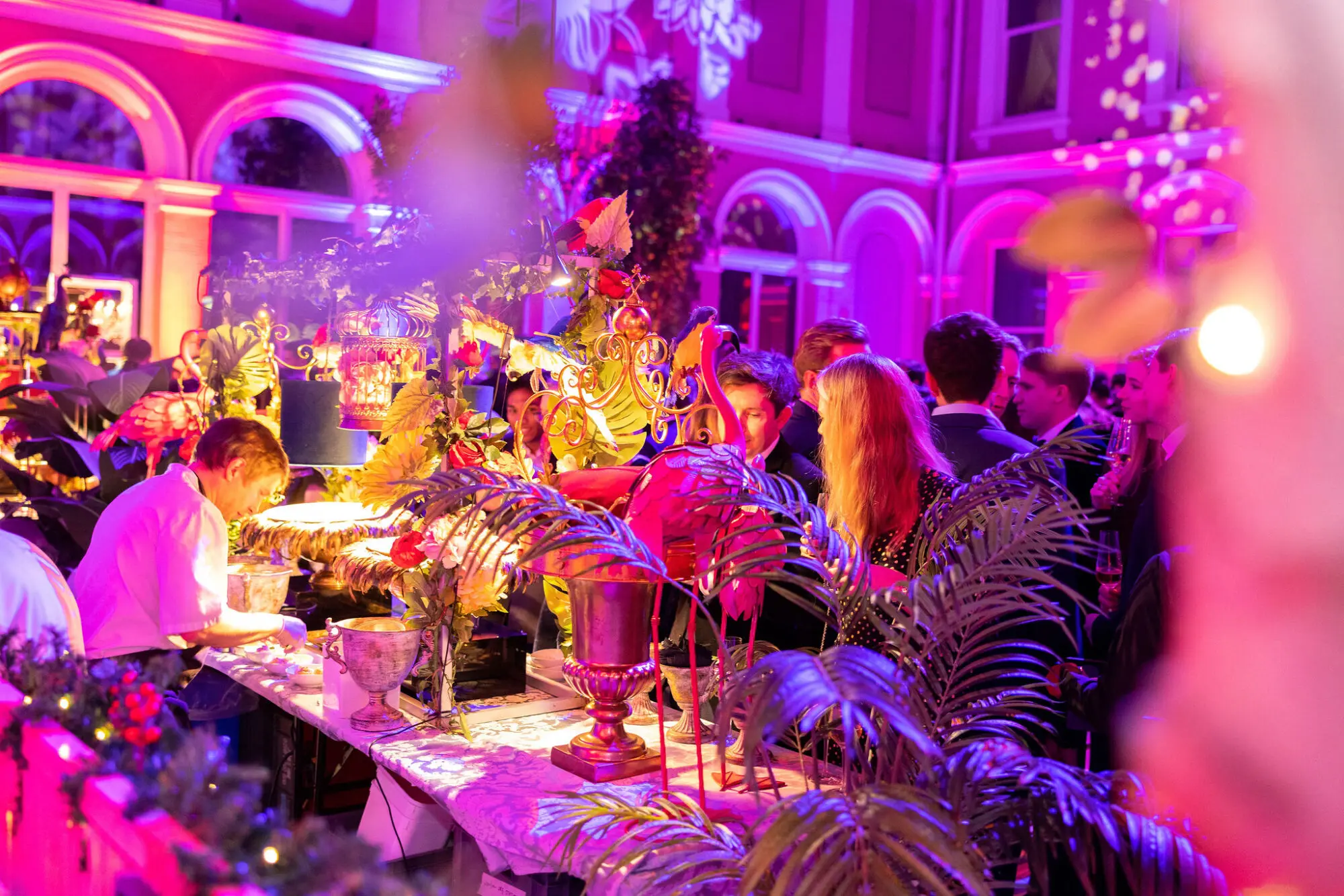 Guests dining at a long table with tropical styling