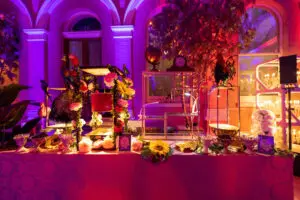 Styled bar with floral displays and lamps at an evening event