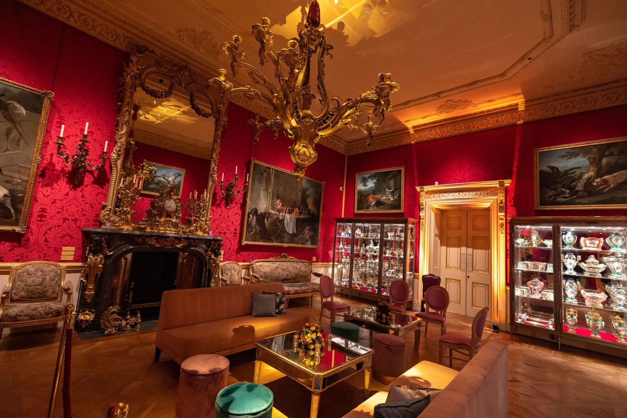 Red drawing room with chandelier and oil paintings