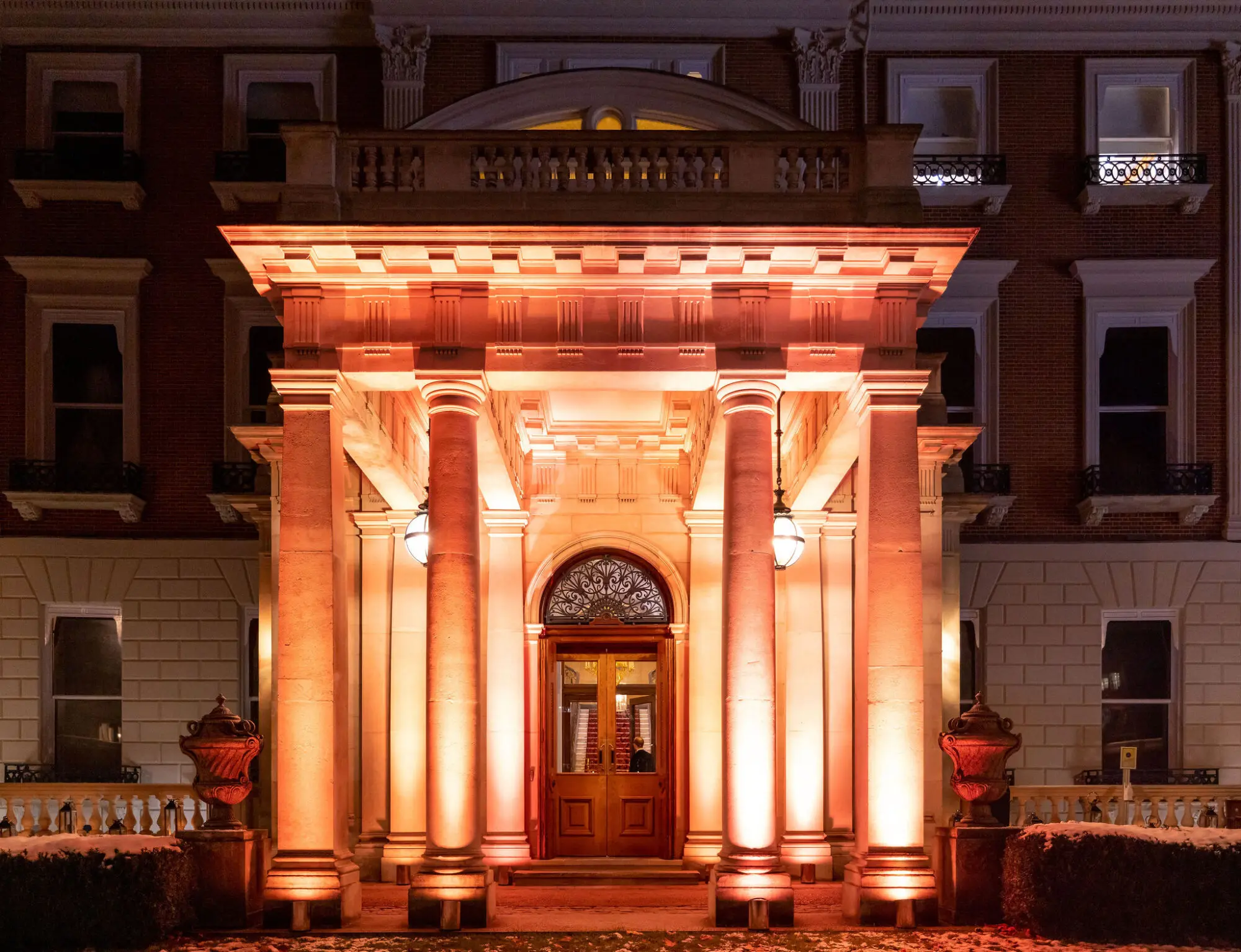 Grand pillared venue entrance lit in amber at night