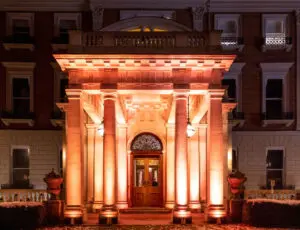 Grand pillared venue entrance lit in amber at night