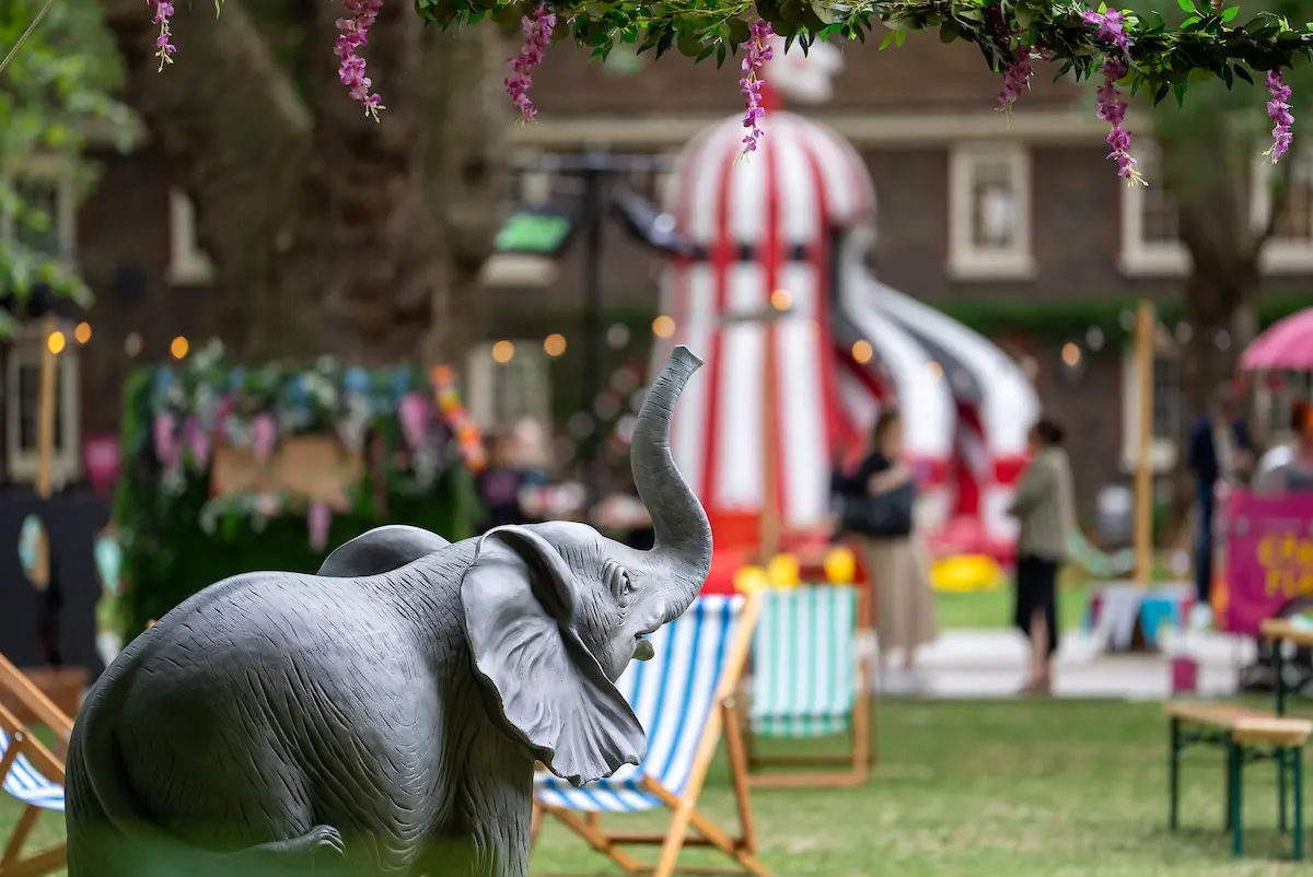 Circus-themed garden party with an elephant sculpture and striped helter skelter