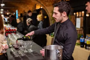 Bartender pouring drinks at a bar during a reception
