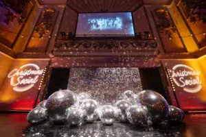 Christmas Social stage with mirror balls and neon signage