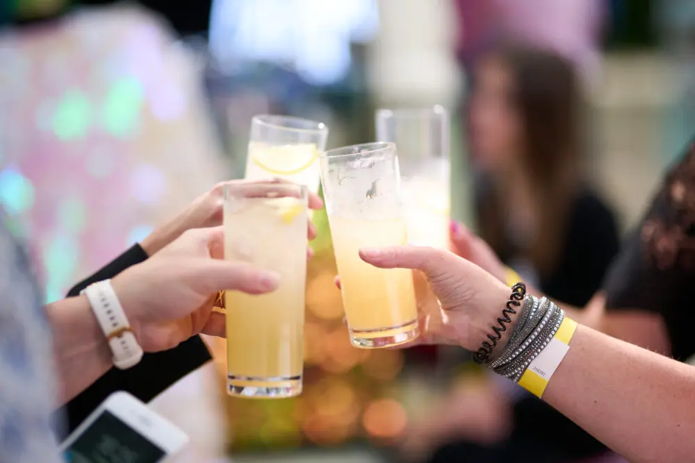 Two guests toasting with cocktails at a summer party